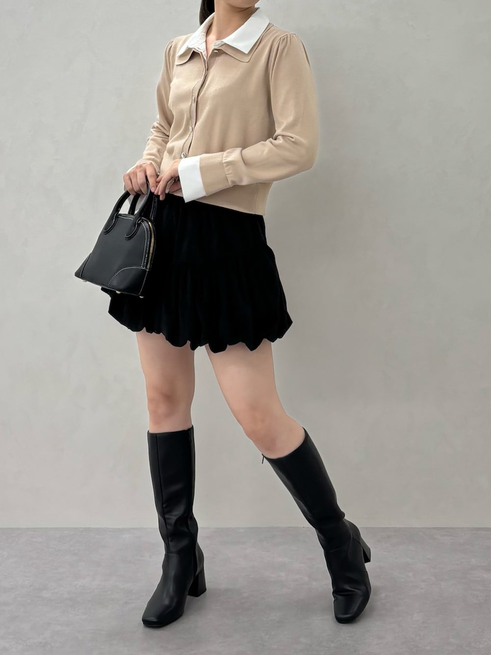 ベージュ系のニット/セーター、ブラック系のバッグを着用したレディースの秋コーディネートの4枚目の写真