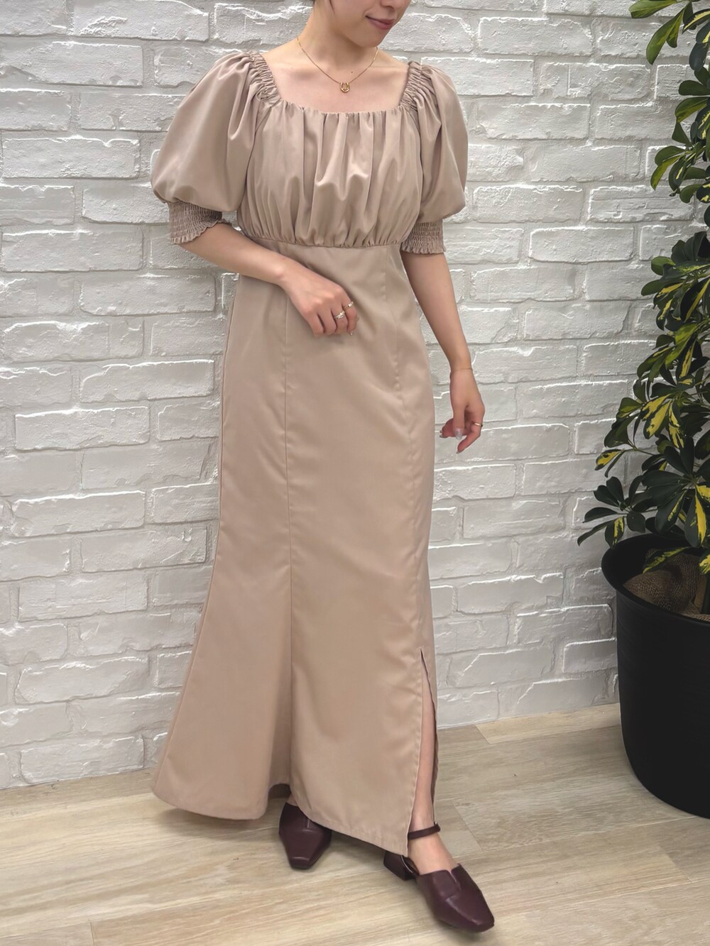 ベージュ系のワンピースを着用したレディースの秋コーディネートの2枚目の写真