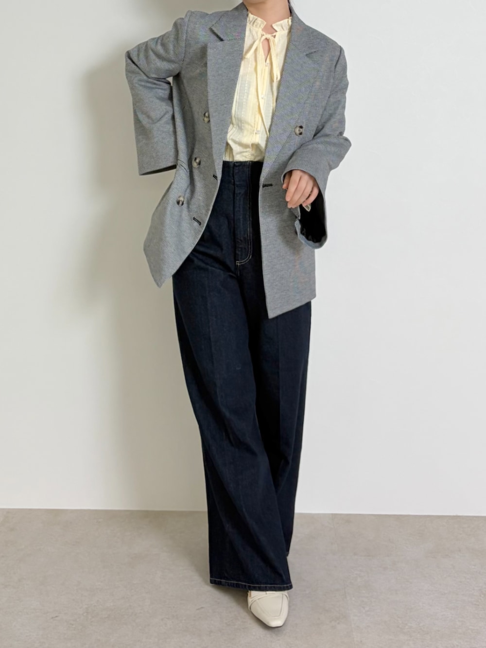 ブルー系のデニムパンツ、ブラック系のパンプス、ブラック系のテーラードジャケットを着用したレディースの春コーディネートの3枚目の写真