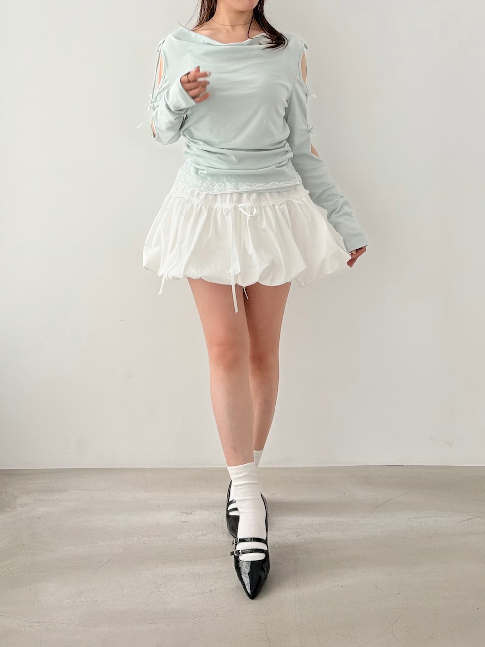 ホワイト系のスカート、ブルー系のTシャツ/カットソーを着用したレディースの春コーディネートの2枚目の写真