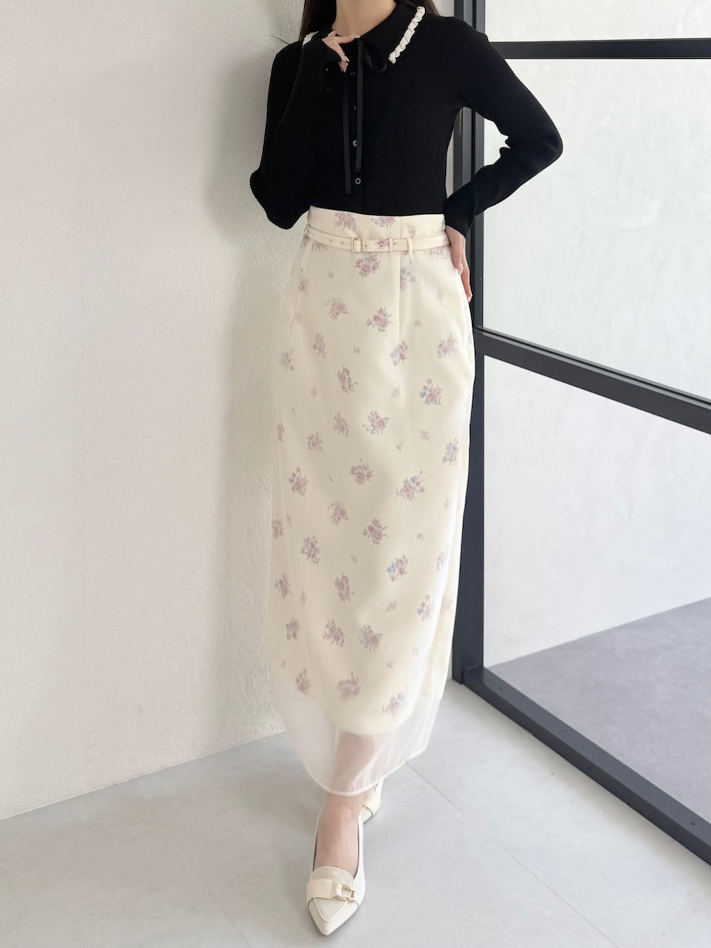 ブラック系のニット/セーター、ベージュ系のシューズ、イエロー系のスカートを着用したレディースの春コーディネートの2枚目の写真