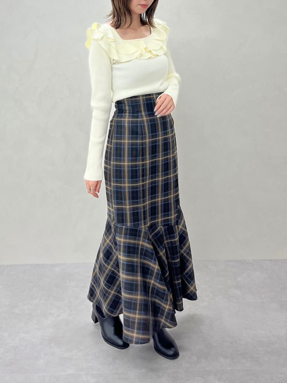 ブルー系のスカート、ホワイト系のニット/セーターを着用したレディースの秋コーディネートの2枚目の写真