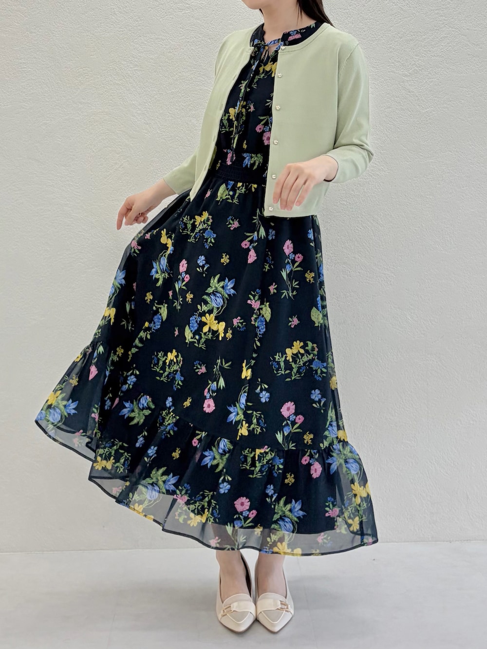 ベージュ系のシューズ、ブルー系のワンピース、グリーン系のカーディガン/ボレロを着用したレディースの春コーディネートの3枚目の写真