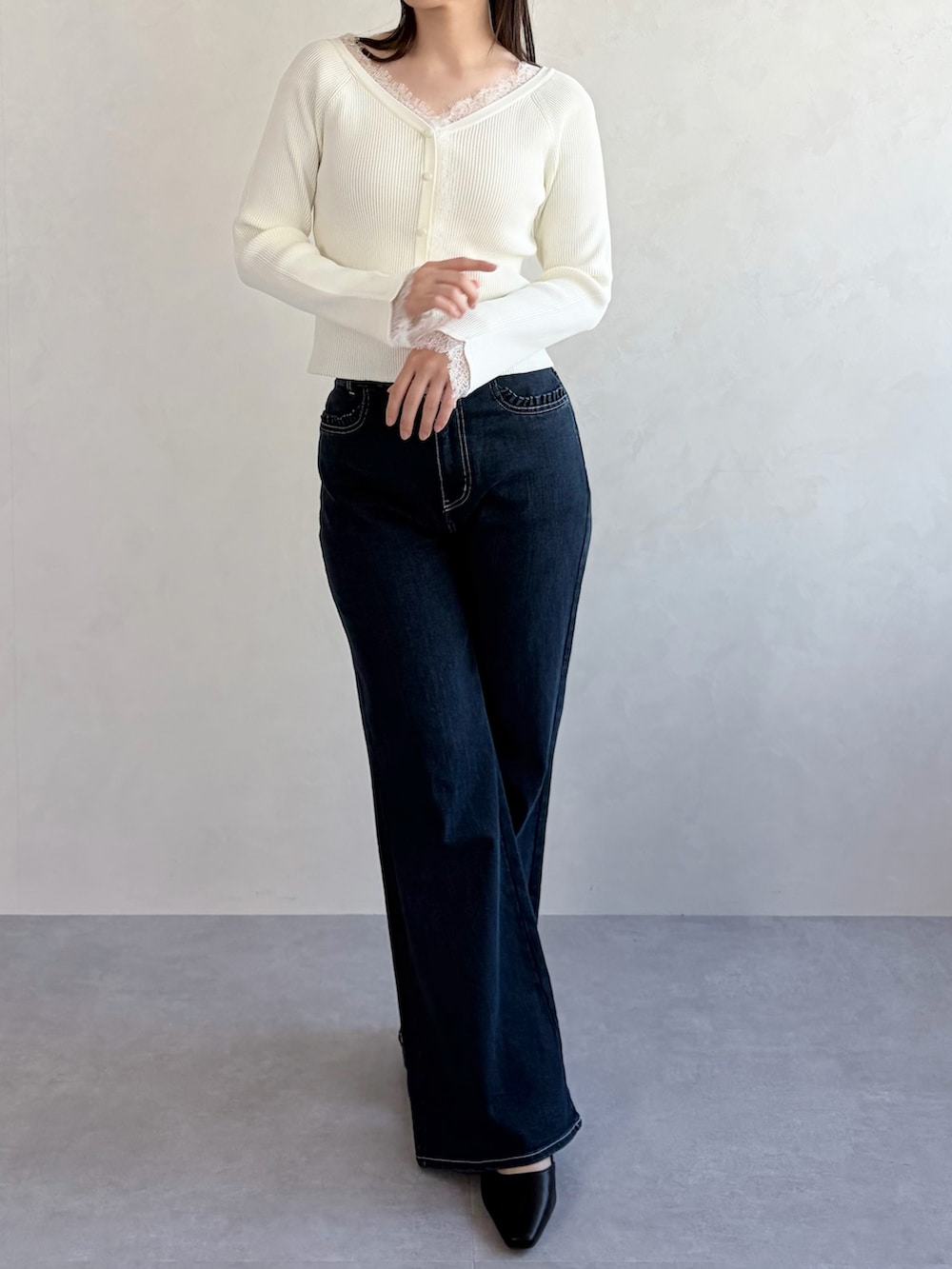 ホワイト系のニット/セーター、ブルー系のデニムパンツを着用したレディースの春コーディネートの2枚目の写真