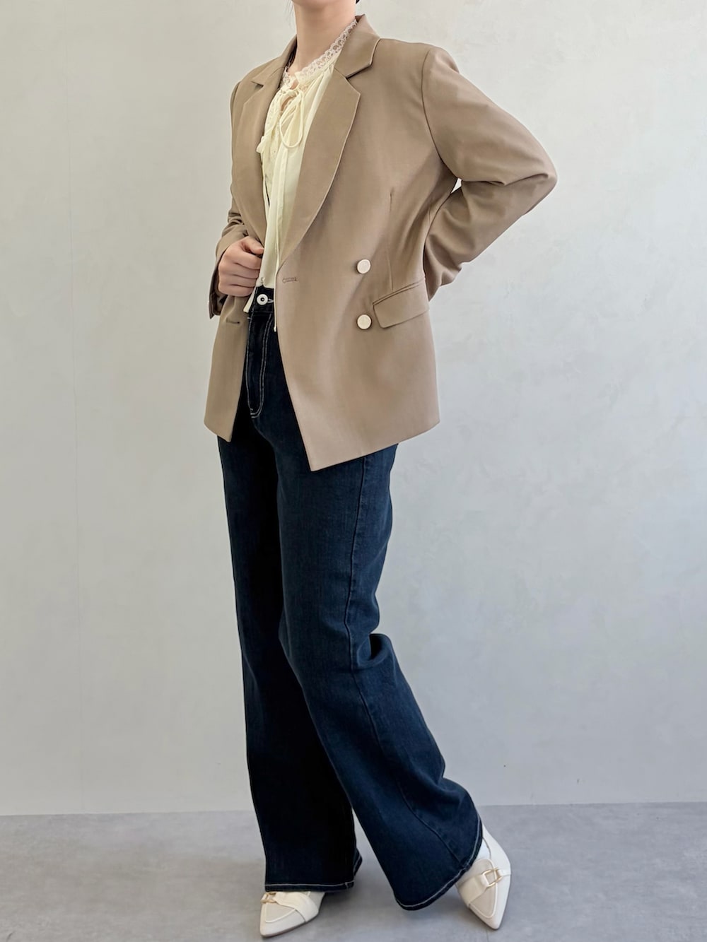 ブルー系のデニムパンツ、ブラウン系のテーラードジャケット、イエロー系のシャツ/ブラウスを着用したレディースの春コーディネートの5枚目の写真