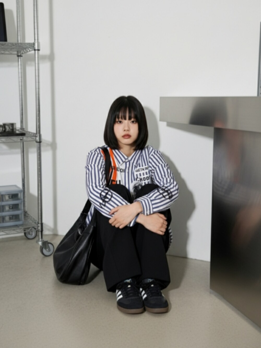 ブラック系のスニーカー、ブラック系のチノパンツ、ブルー系のシャツ/ブラウスを着用したレディースの秋コーディネートの4枚目の写真