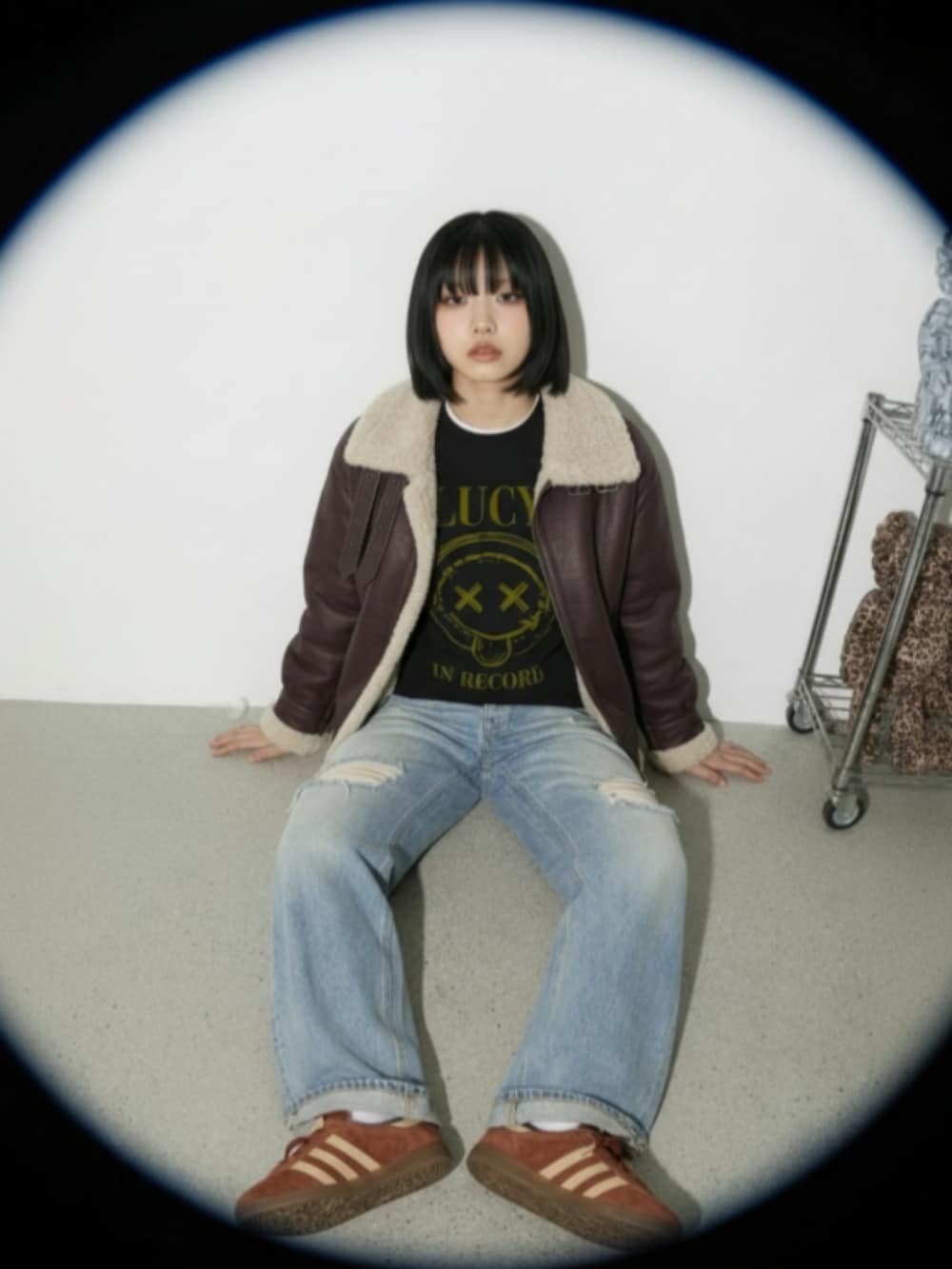 ブラウン系のスニーカー、ブルー系のデニムパンツ、ブラック系のスウェットを着用したレディースの秋コーディネートの5枚目の写真