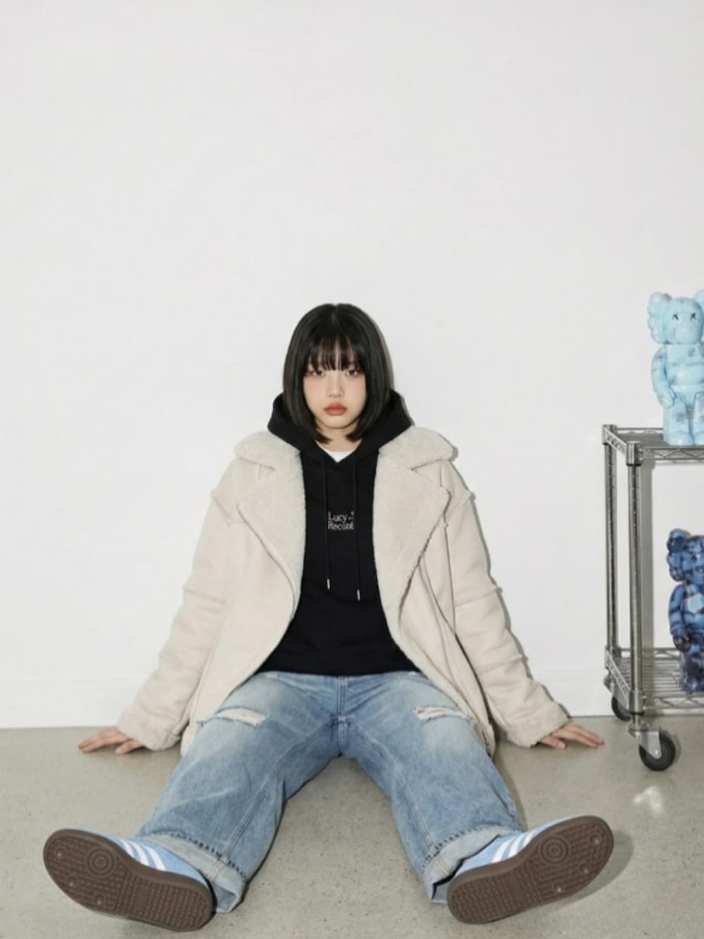 ブルー系のスニーカー、ブルー系のデニムパンツ、ブラック系のパーカーを着用したレディースの冬コーディネートの2枚目の写真