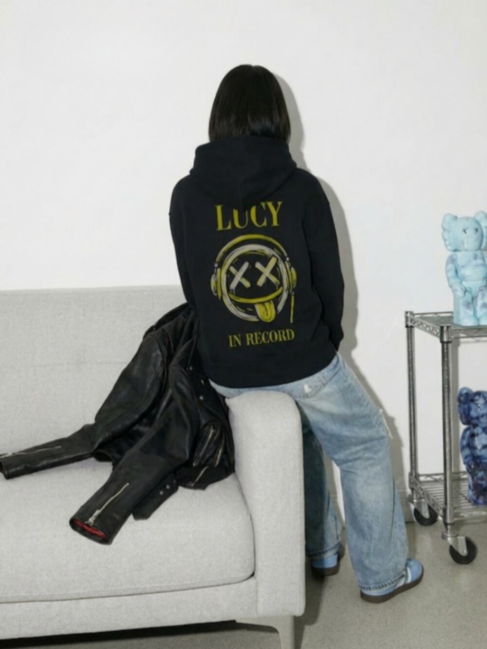 ブルー系のスニーカー、ブルー系のデニムパンツ、ブラック系のパーカーを着用したレディースの冬コーディネートの3枚目の写真