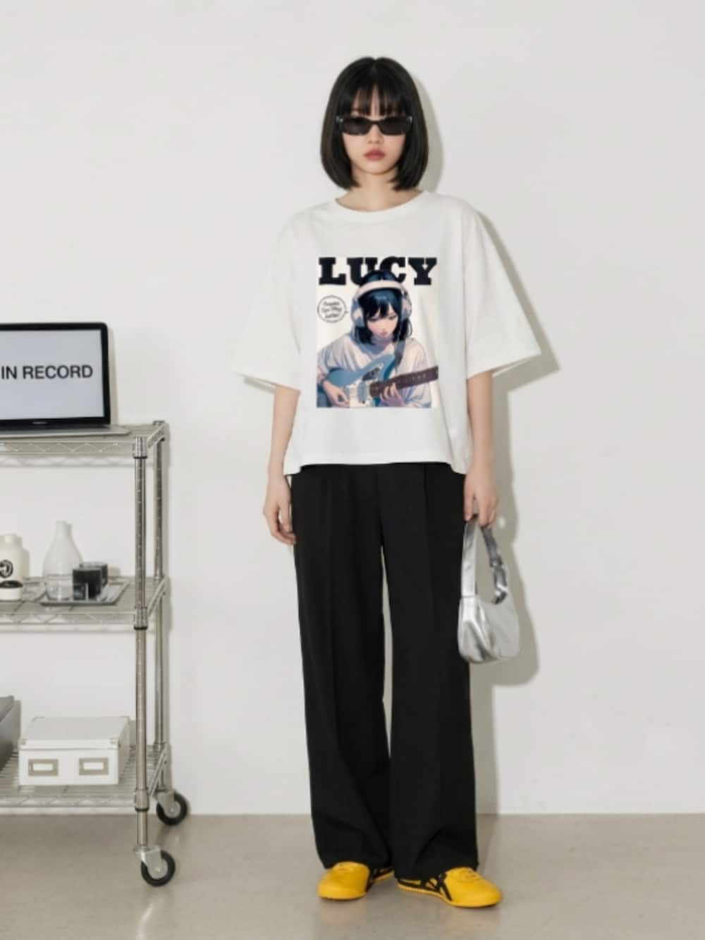 ブラック系のスニーカー、ブラック系のスカート、ホワイト系のTシャツ/カットソーを着用したレディースの夏コーディネートの2枚目の写真