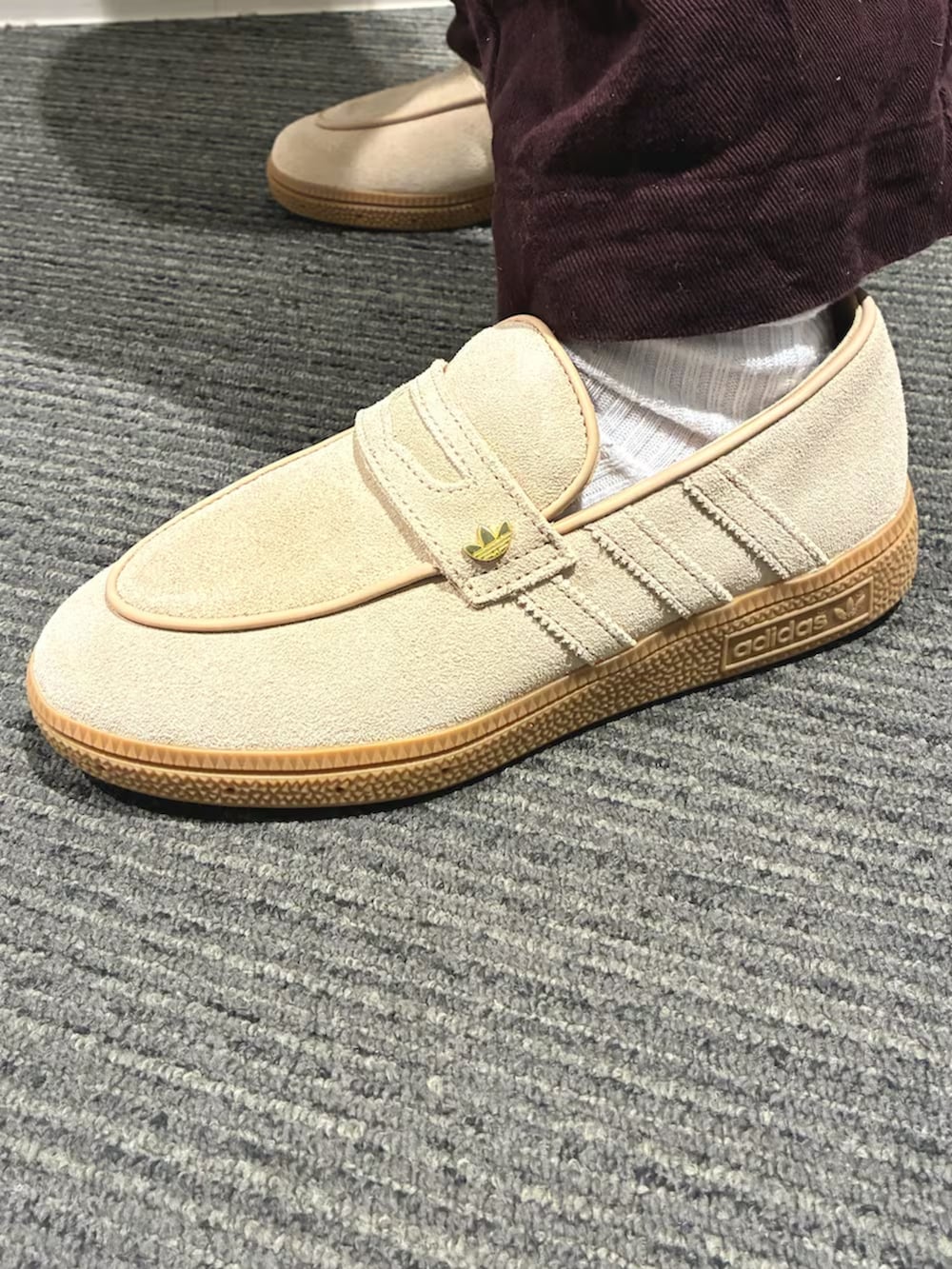 ブラウン系のショルダーバッグ、ベージュ系のスニーカー、ブルー系のジャージを着用したレディースの春コーディネートの3枚目の写真