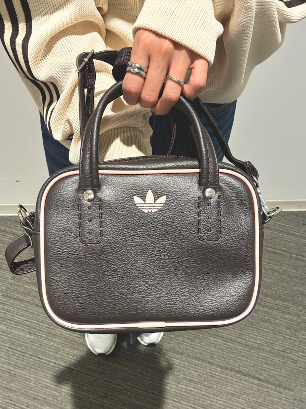 ホワイト系のジャージ、ブルー系のデニムスカート、シルバー系のスニーカーを着用したレディースの春コーディネートの6枚目の写真