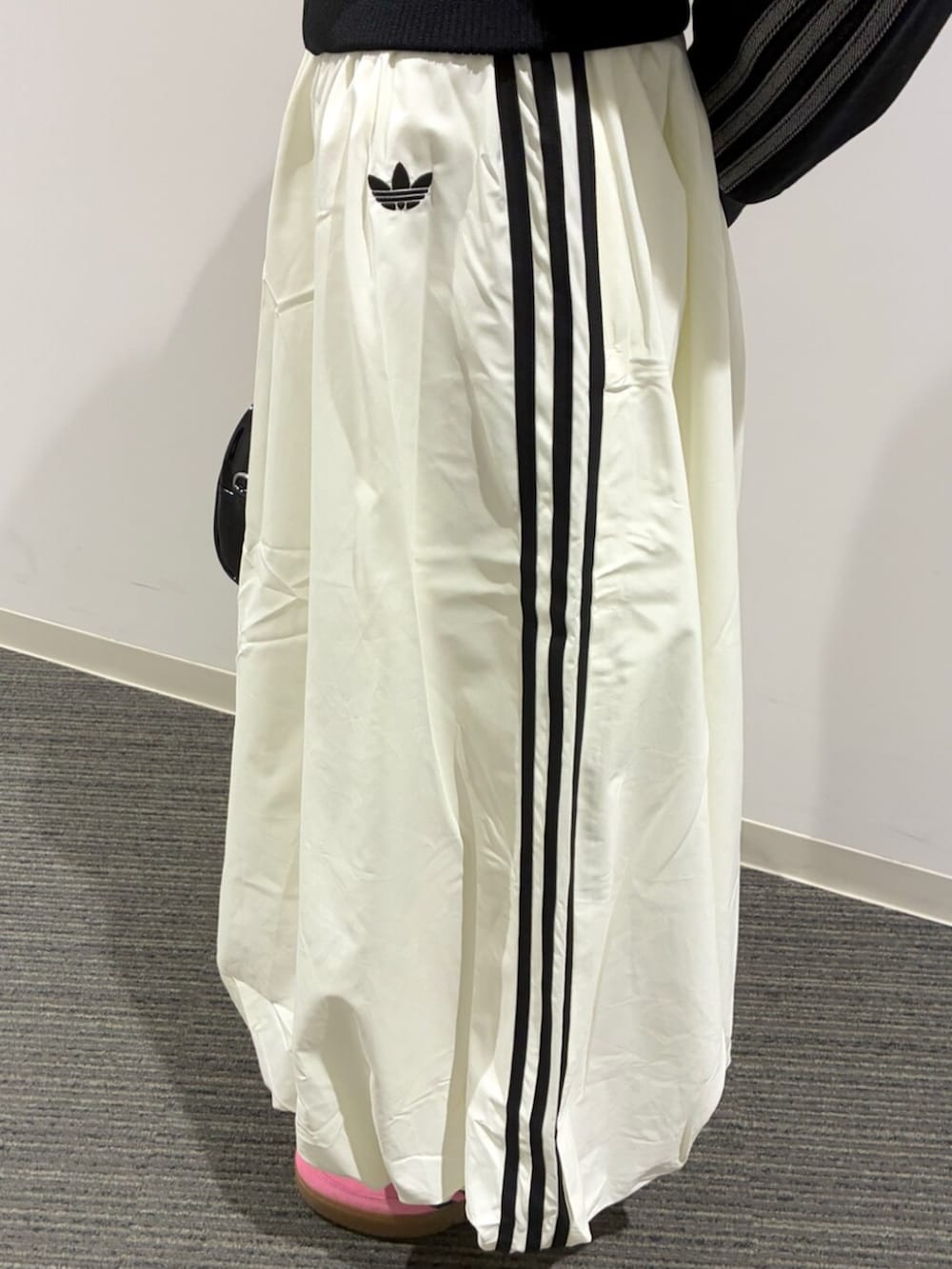 ブラック系のショルダーバッグ、ブラック系のデニムジャケット、ホワイト系のスカートを着用したレディースの冬コーディネートの4枚目の写真