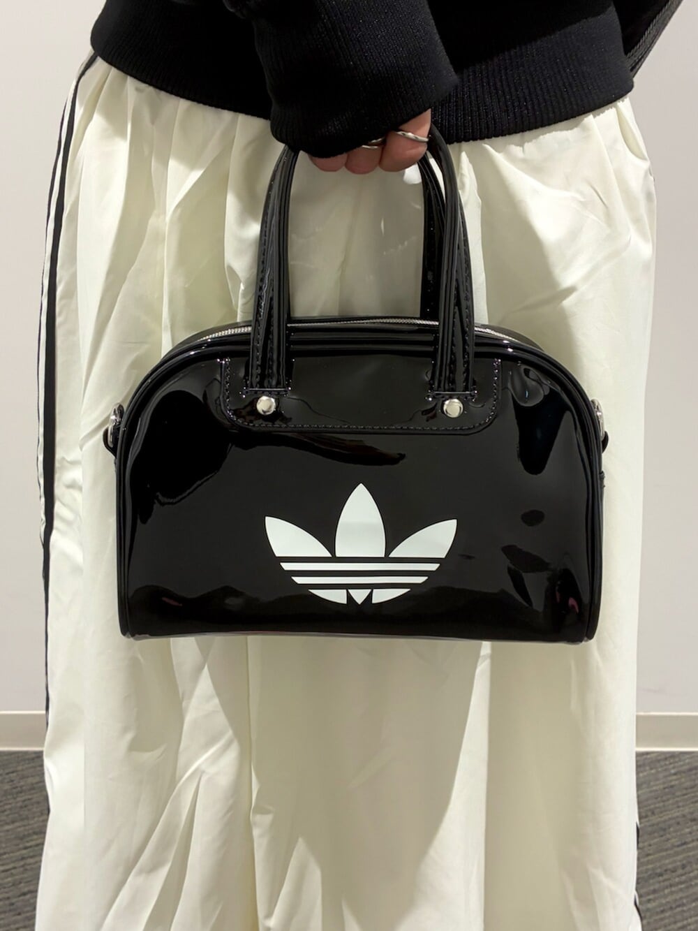 ブラック系のショルダーバッグ、ブラック系のデニムジャケット、ホワイト系のスカートを着用したレディースの冬コーディネートの6枚目の写真