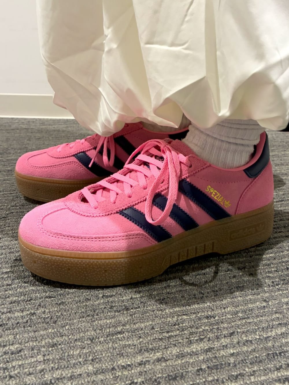 ブラック系のショルダーバッグ、ブラック系のデニムジャケット、ホワイト系のスカートを着用したレディースの冬コーディネートの5枚目の写真