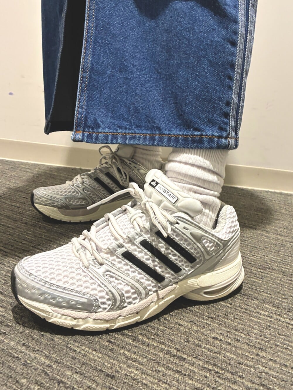 ホワイト系のジャージ、ブルー系のデニムスカート、シルバー系のスニーカーを着用したレディースの春コーディネートの5枚目の写真