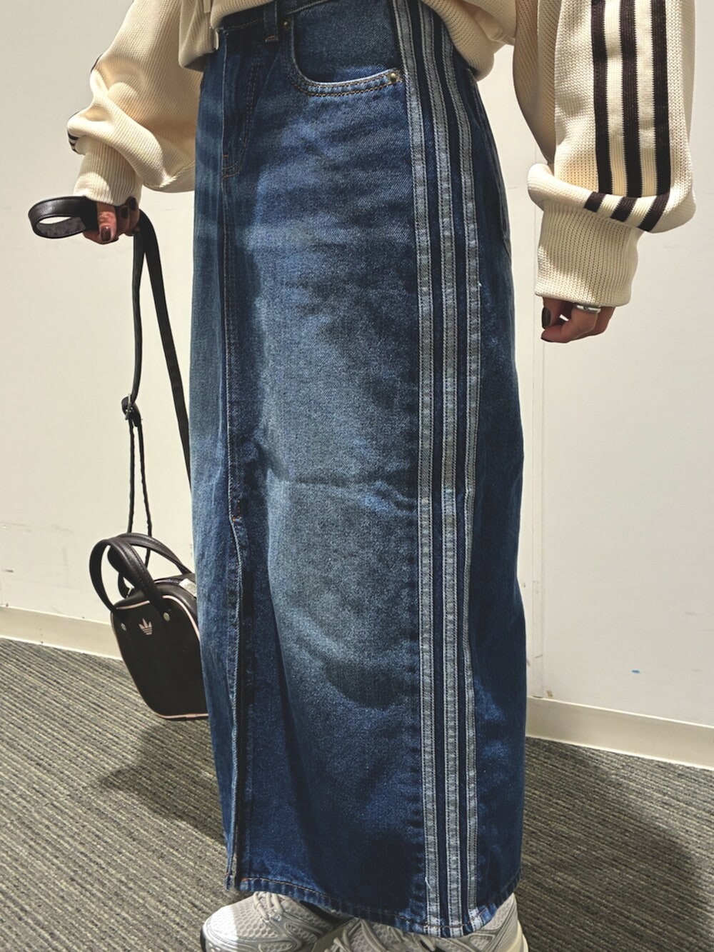 ホワイト系のジャージ、ブルー系のデニムスカート、シルバー系のスニーカーを着用したレディースの春コーディネートの4枚目の写真