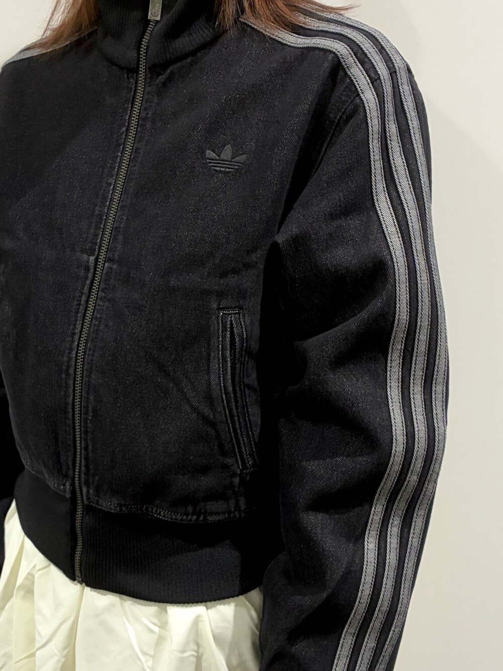 ブラック系のショルダーバッグ、ブラック系のデニムジャケット、ホワイト系のスカートを着用したレディースの冬コーディネートの3枚目の写真