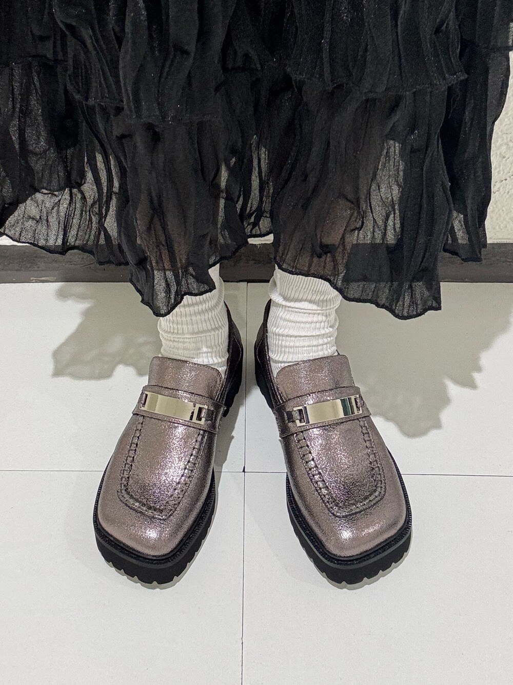 ブラック系のボストンバッグ、シルバー系のローファーを着用したレディースの冬コーディネートの2枚目の写真