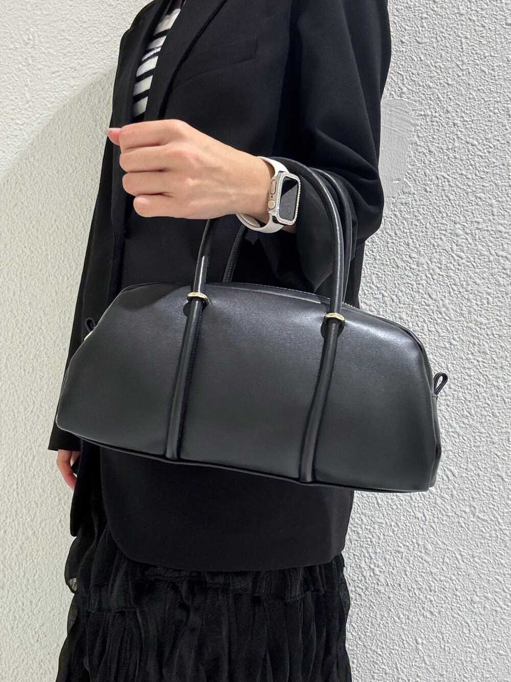 ブラック系のボストンバッグ、シルバー系のローファーを着用したレディースの冬コーディネートの3枚目の写真