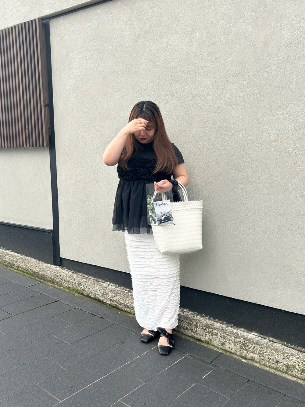 ホワイト系のスカート、ブラック系のシューズ、ブラック系のTシャツ/カットソーを着用したレディースの夏コーディネートの2枚目の写真