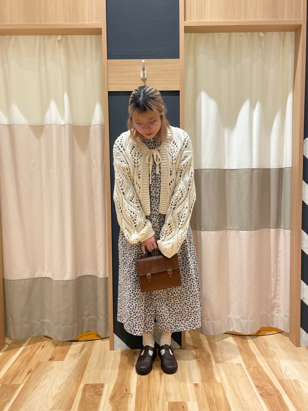 ホワイト系のカーディガン/ボレロ、ベージュ系のワンピース、ブラウン系のハンドバッグを着用したレディースの冬コーディネートの5枚目の写真