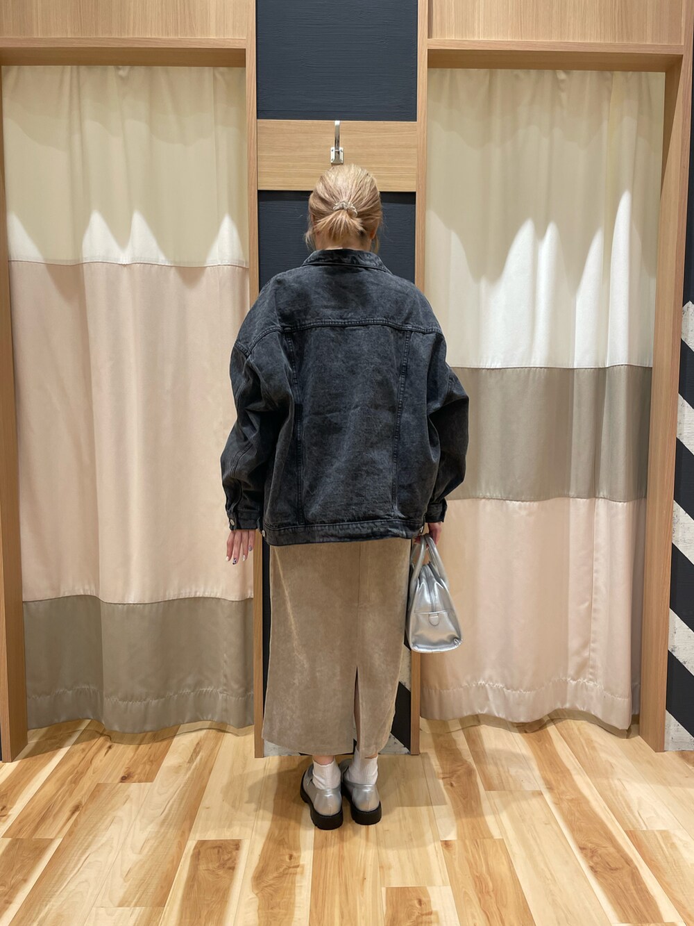 シルバー系のハンドバッグ、ブラック系のノーカラージャケット、ホワイト系のTシャツ/カットソーを着用したレディースの秋コーディネートの3枚目の写真