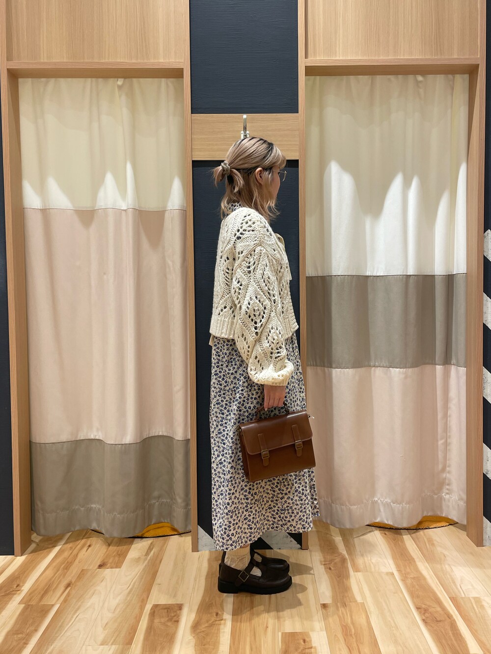 ホワイト系のカーディガン/ボレロ、ベージュ系のワンピース、ブラウン系のハンドバッグを着用したレディースの冬コーディネートの2枚目の写真