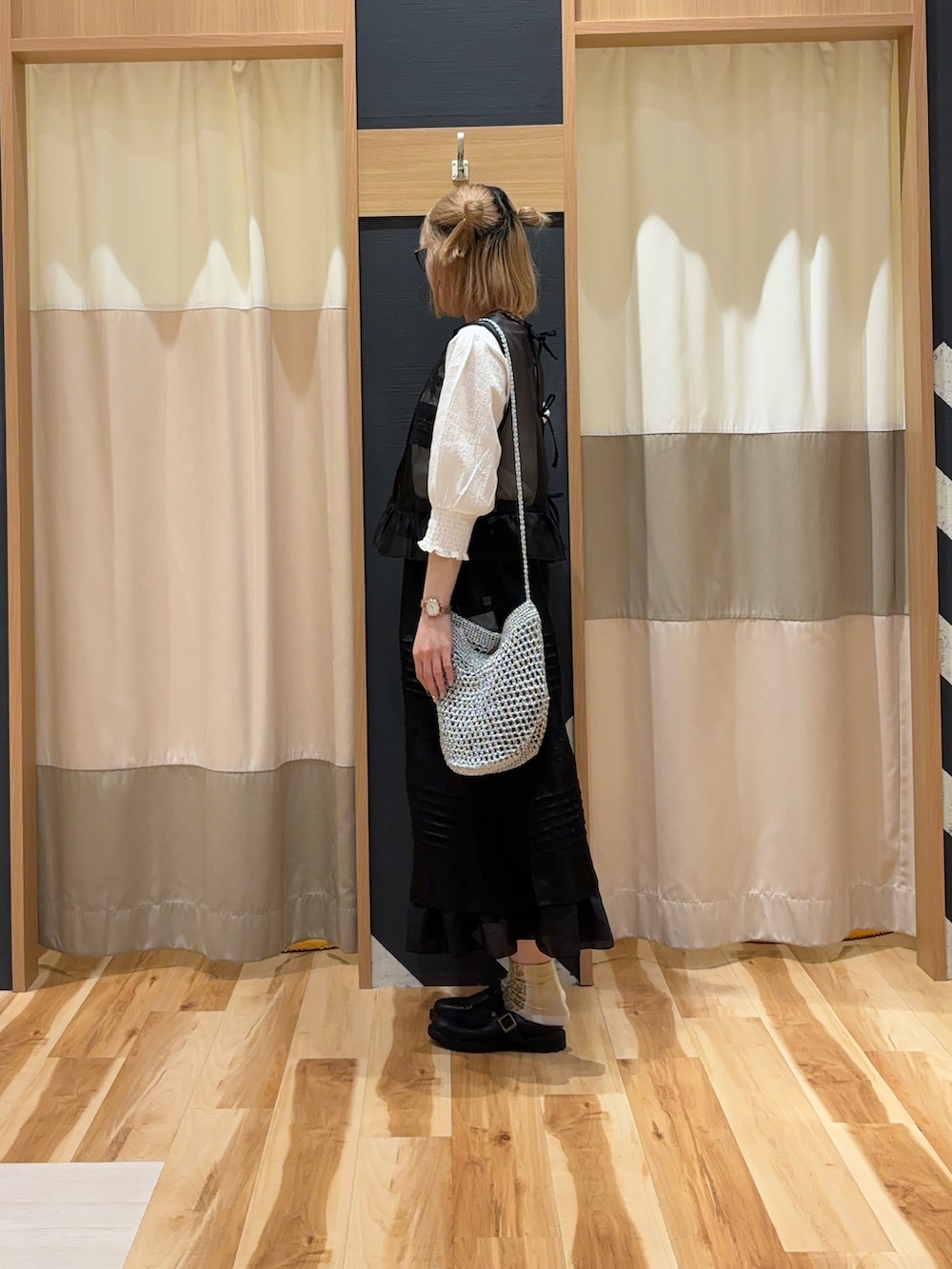 ブラック系のベスト、ホワイト系のTシャツ/カットソー、シルバー系のハンドバッグを着用したレディースの春コーディネートの4枚目の写真