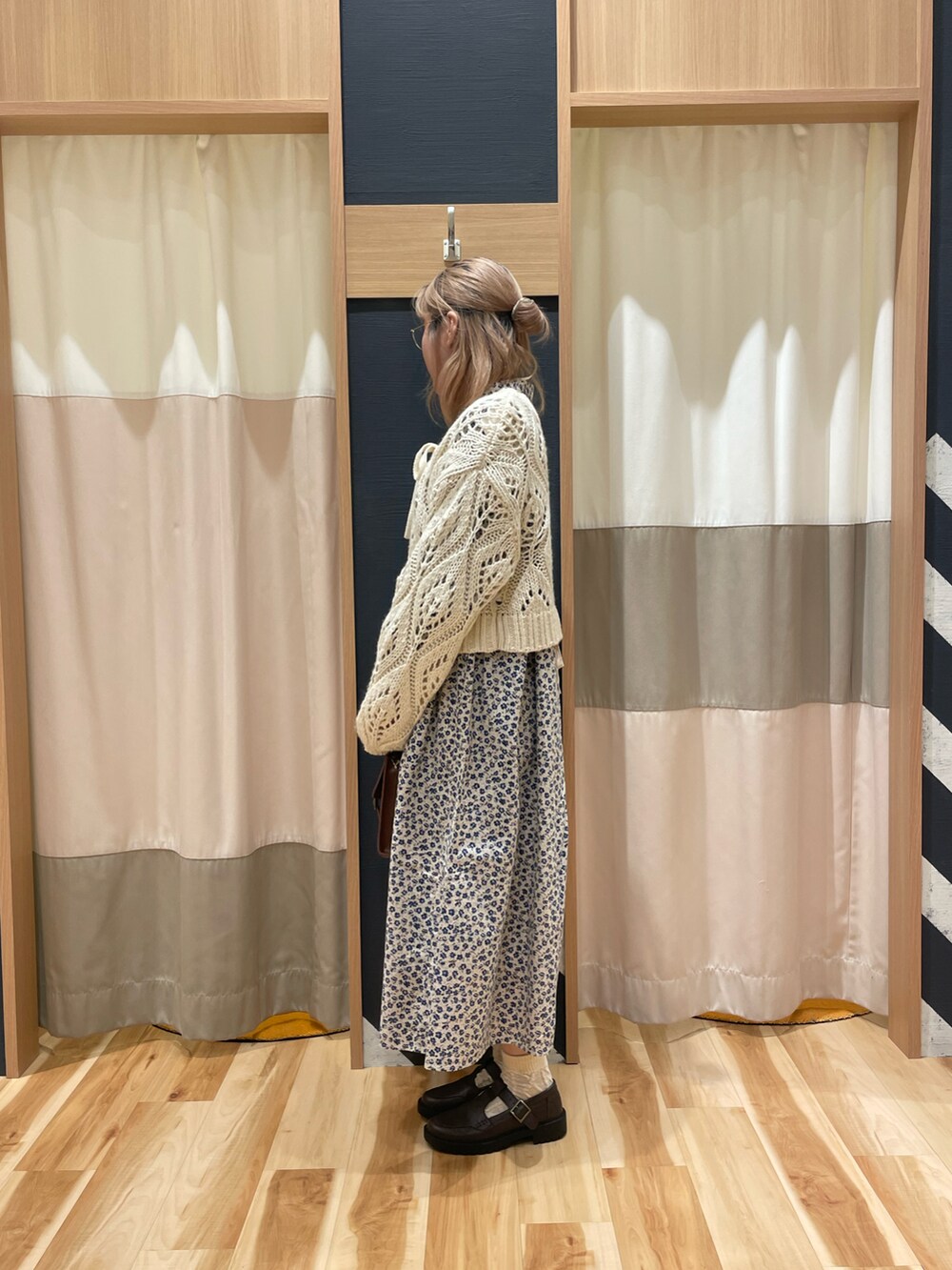 ホワイト系のカーディガン/ボレロ、ベージュ系のワンピース、ブラウン系のハンドバッグを着用したレディースの冬コーディネートの4枚目の写真