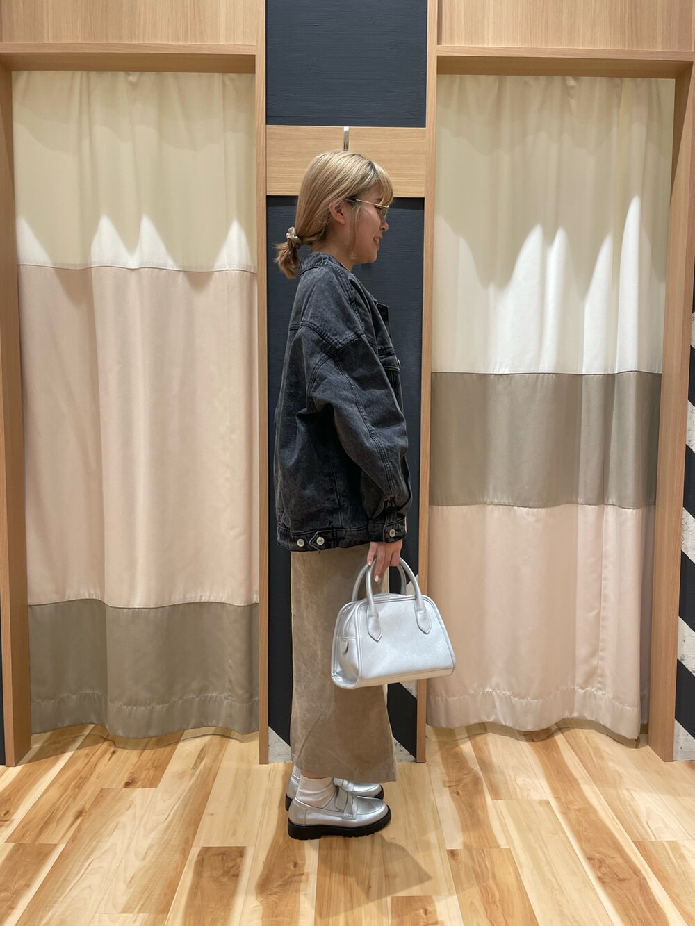 シルバー系のハンドバッグ、ブラック系のノーカラージャケット、ホワイト系のTシャツ/カットソーを着用したレディースの秋コーディネートの2枚目の写真