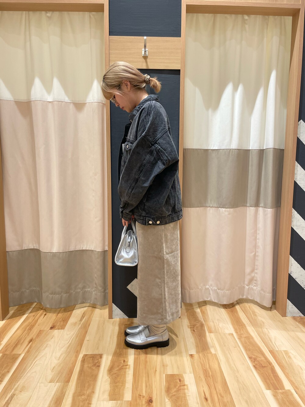 シルバー系のハンドバッグ、ブラック系のノーカラージャケット、ホワイト系のTシャツ/カットソーを着用したレディースの秋コーディネートの4枚目の写真