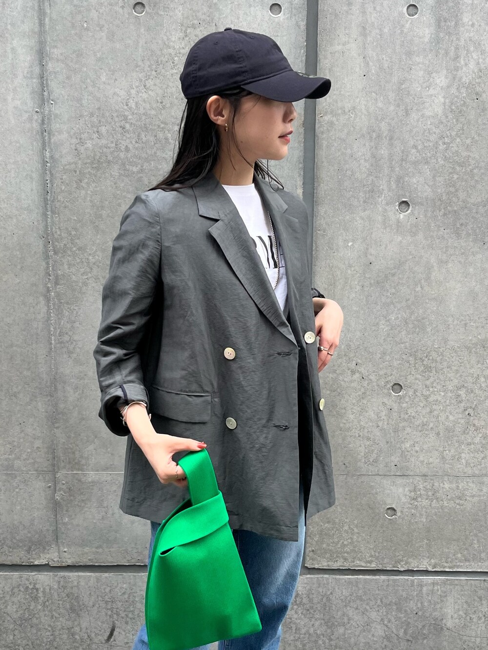 グレー系のテーラードジャケット、ホワイト系のTシャツ/カットソー、ブルー系のデニムパンツを着用したレディースの春コーディネートの4枚目の写真