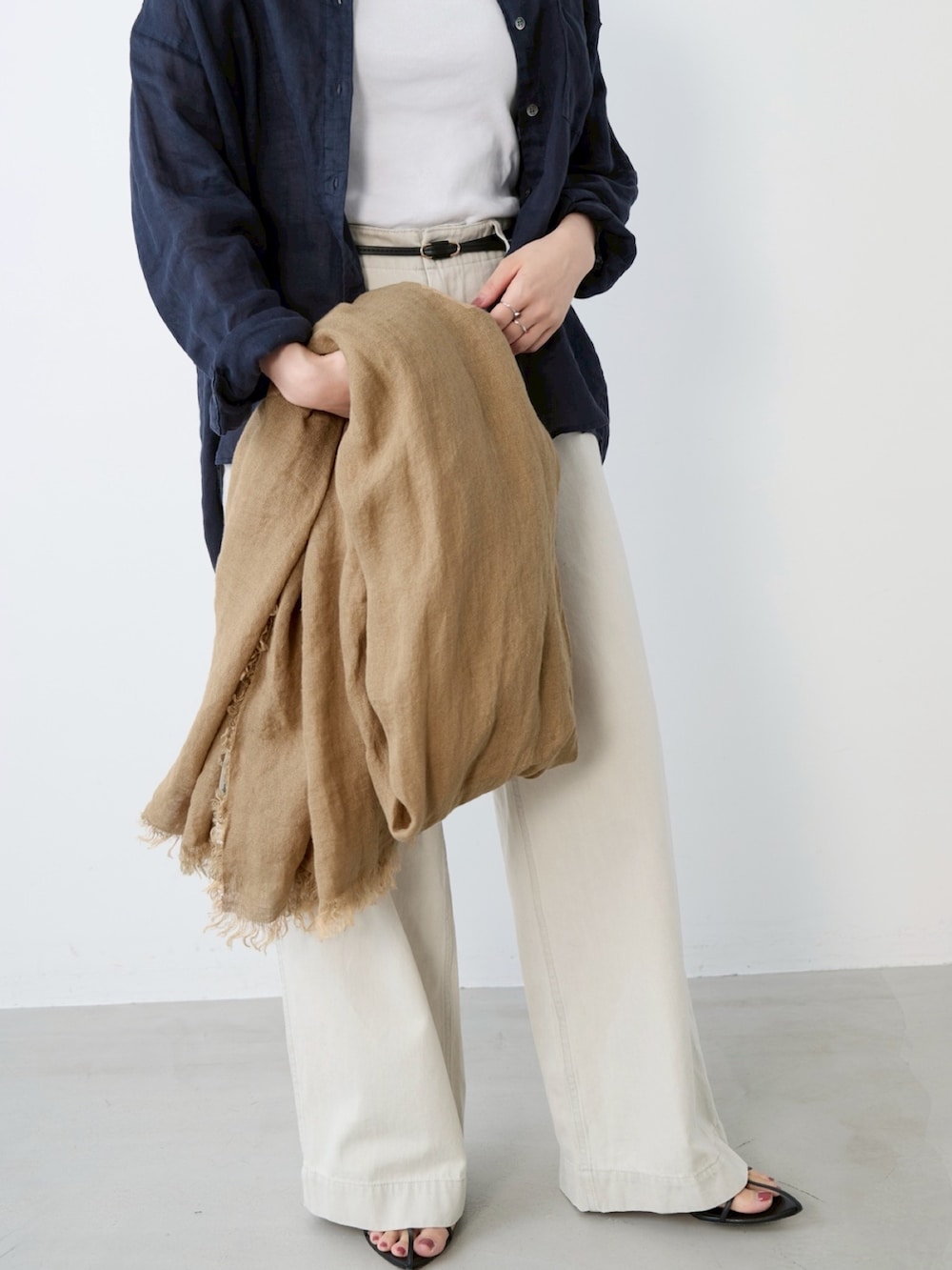 グレー系のチノパンツ、ベージュ系のストール/ショールを着用したレディースの春コーディネートの4枚目の写真