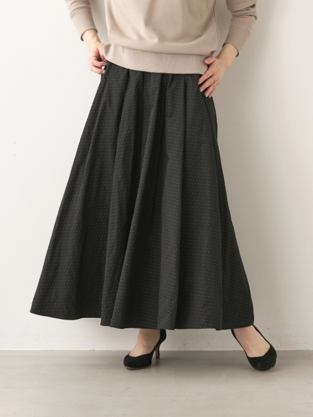 ベージュ系のスウェット、ブラック系のスカートを着用したレディースの秋コーディネートの3枚目の写真