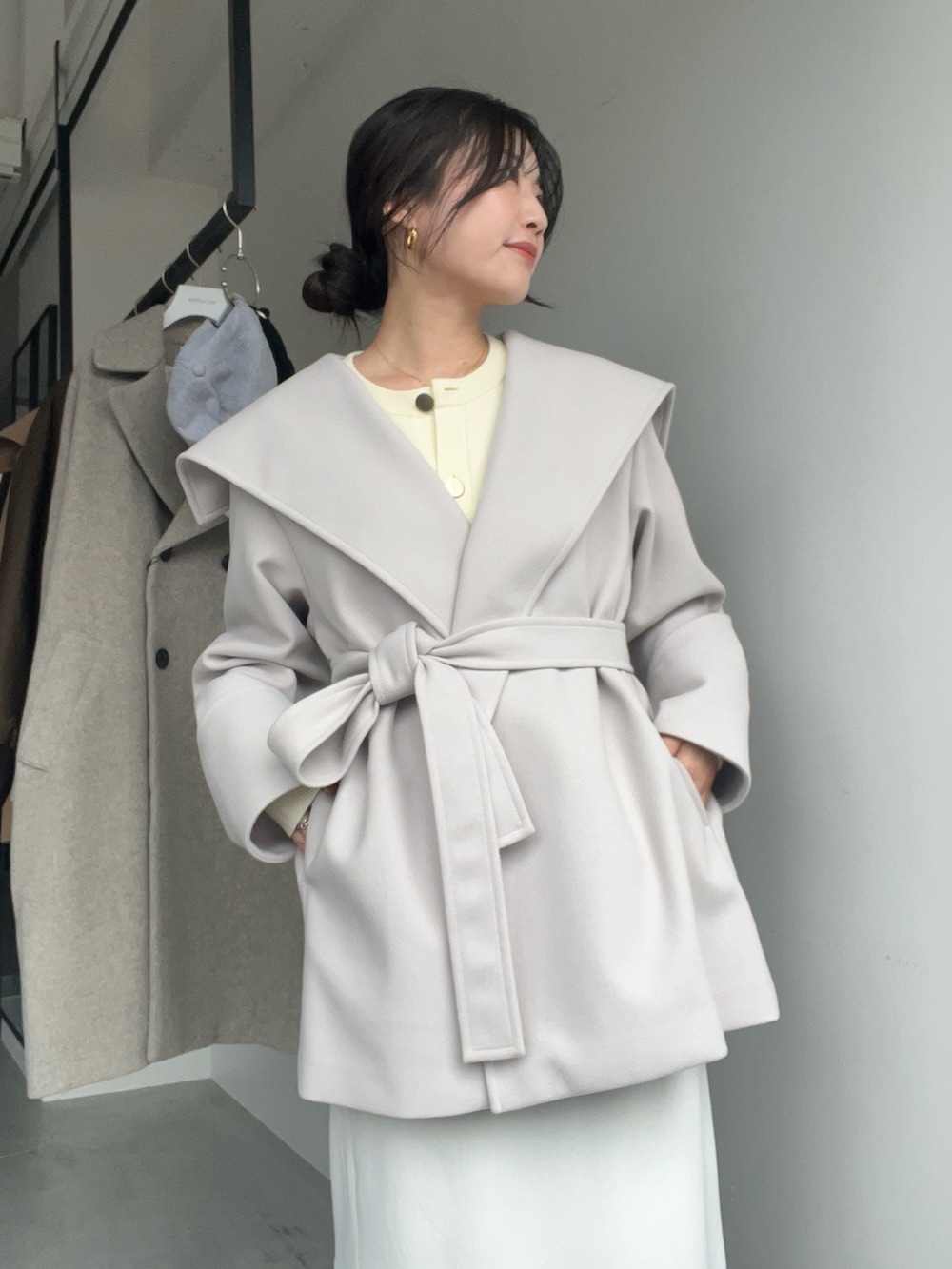 ベージュ系のその他アウター、ホワイト系のスカートを着用したレディースの秋コーディネートの2枚目の写真