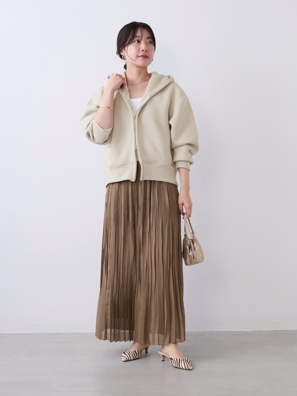 ベージュ系のパーカー、ベージュ系のスカートを着用したレディースの春コーディネートの5枚目の写真
