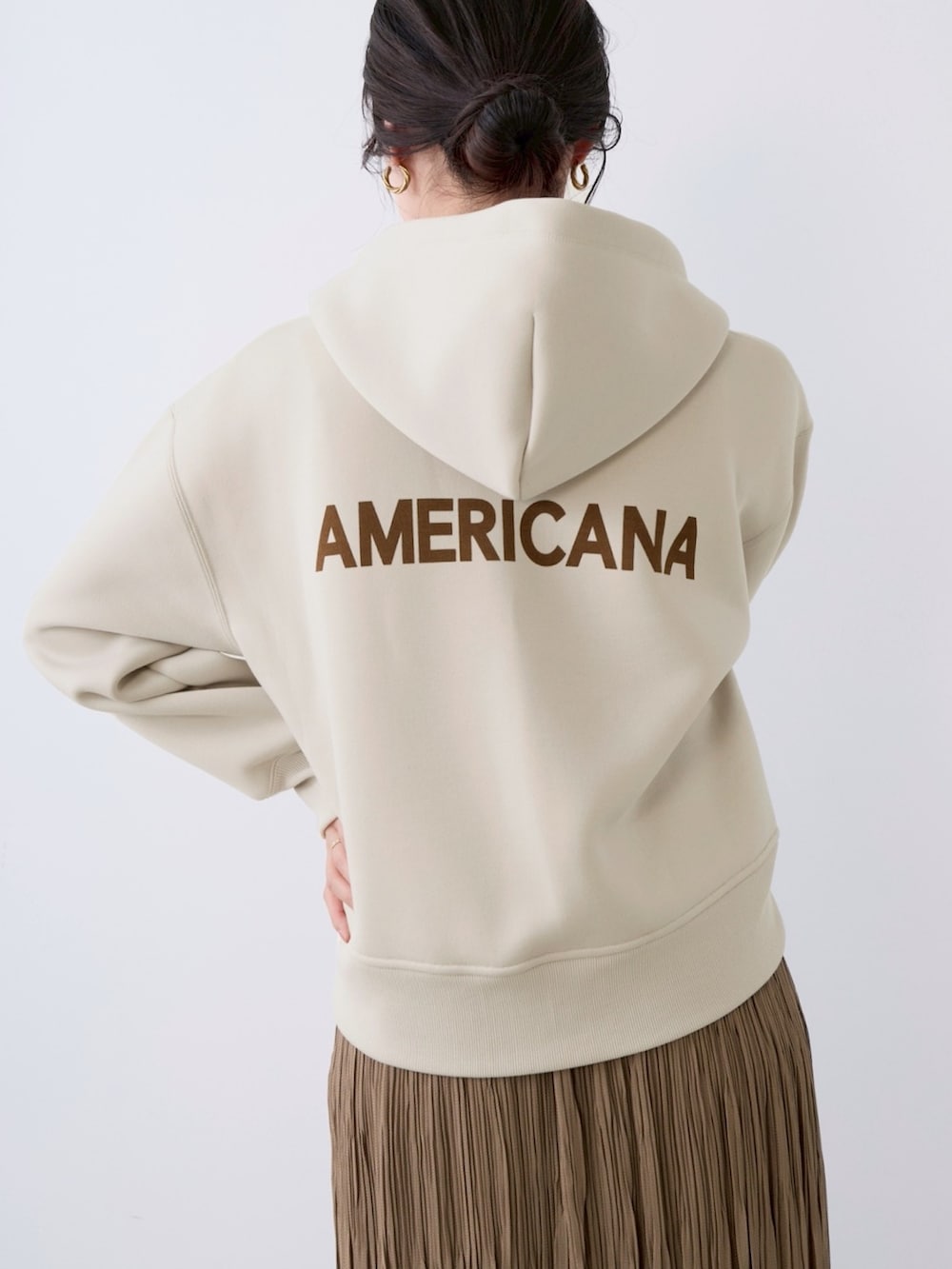 ベージュ系のパーカー、ベージュ系のスカートを着用したレディースの春コーディネートの3枚目の写真