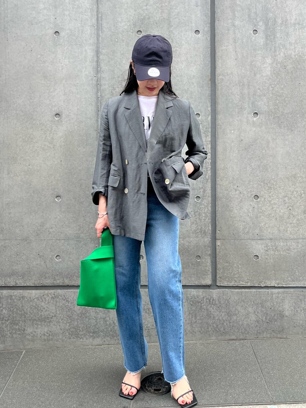 グレー系のテーラードジャケット、ホワイト系のTシャツ/カットソー、ブルー系のデニムパンツを着用したレディースの春コーディネートの3枚目の写真