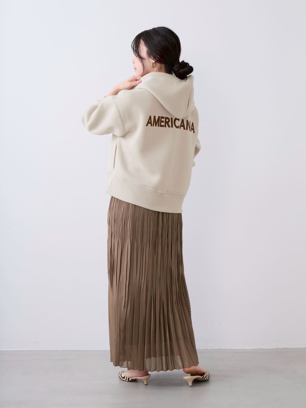 ベージュ系のパーカー、ベージュ系のスカートを着用したレディースの春コーディネートの2枚目の写真