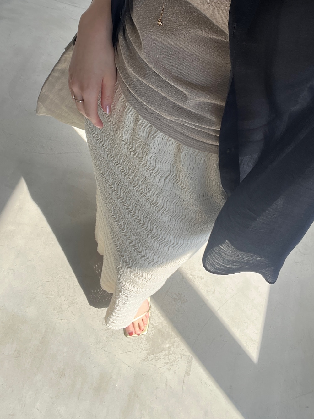 ブルー系のシャツ/ブラウス、ブラウン系のタンクトップを着用したレディースの春コーディネートの3枚目の写真