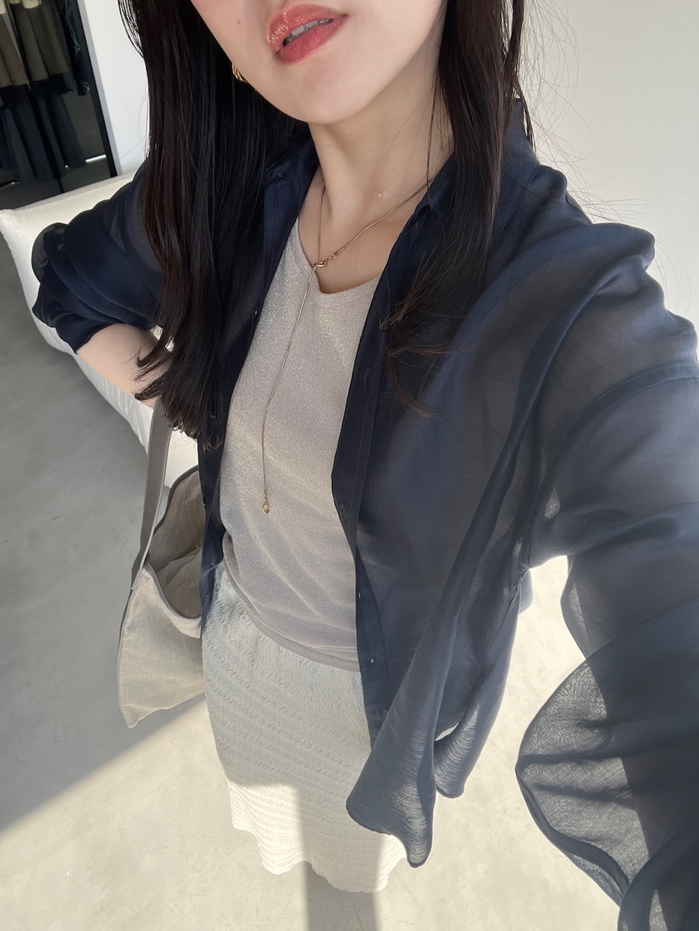 ブルー系のシャツ/ブラウス、ブラウン系のタンクトップを着用したレディースの春コーディネートの2枚目の写真