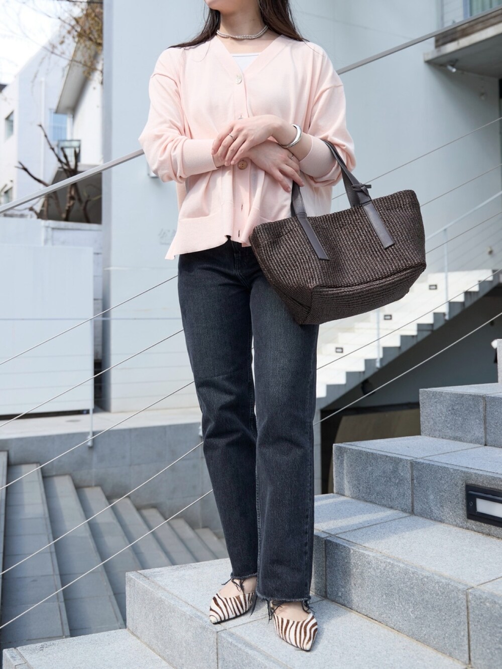 ピンク系のカーディガン/ボレロ、ブラック系のデニムパンツ、ブラウン系のトートバッグを着用したレディースの春コーディネートの4枚目の写真