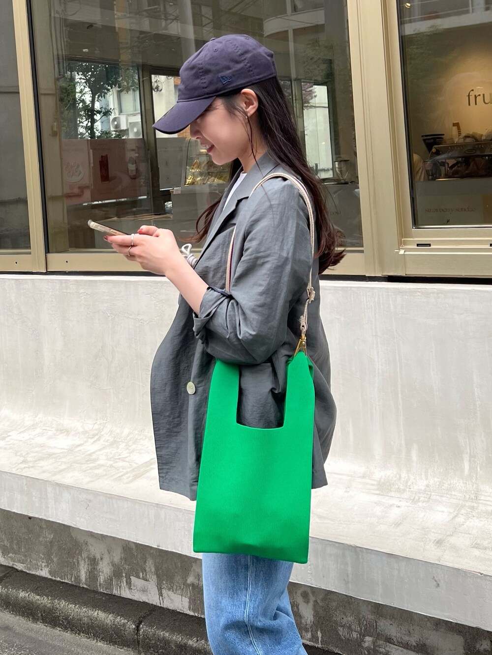 グレー系のテーラードジャケット、ホワイト系のTシャツ/カットソー、ブルー系のデニムパンツを着用したレディースの春コーディネートの6枚目の写真