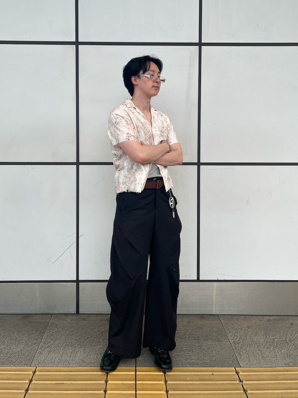 オレンジ系のシャツ/ブラウス、ブラック系のパンツ、グリーン系のローファーを着用したメンズの夏コーディネートの2枚目の写真