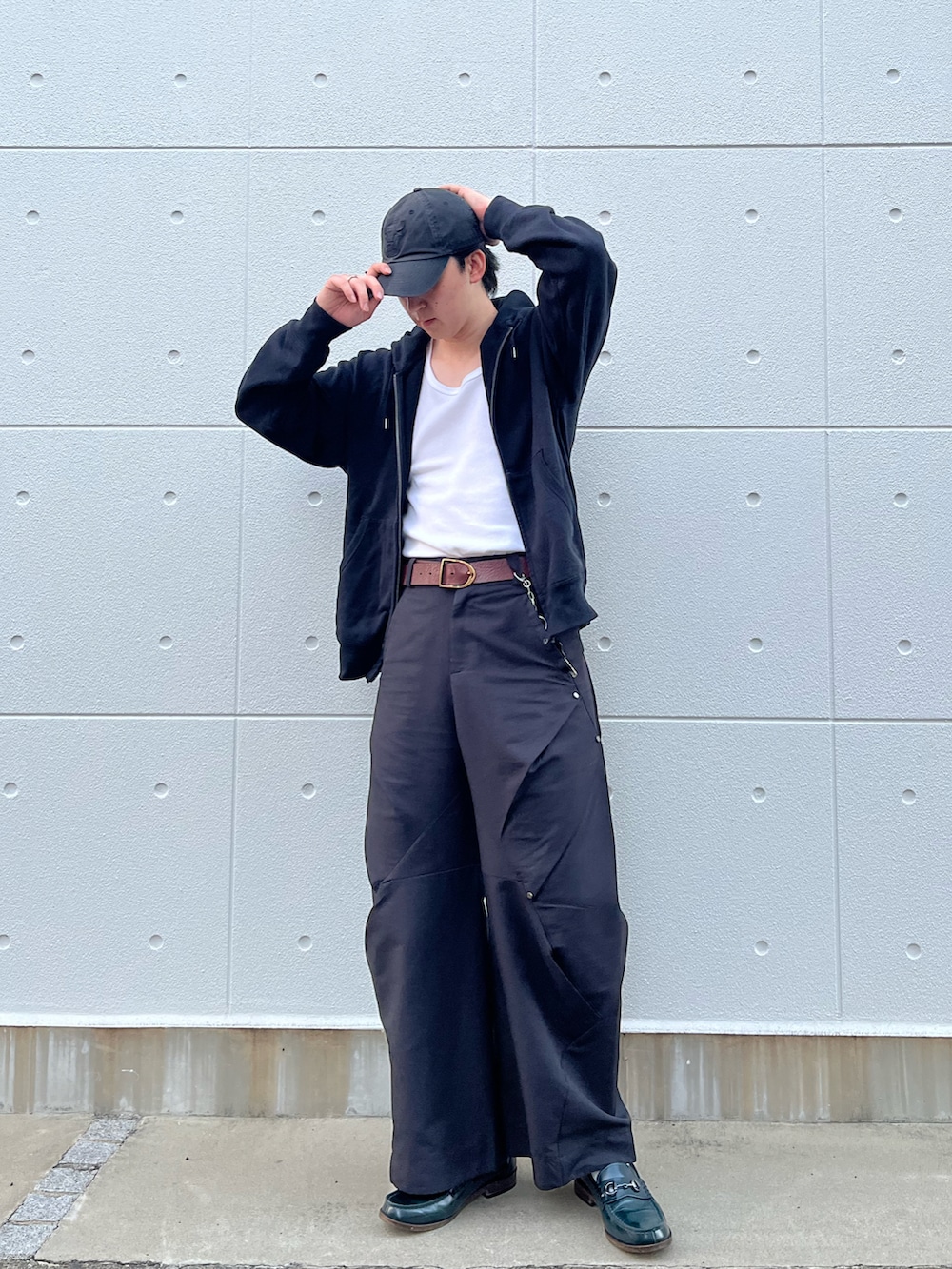ブラック系のパーカー、ブラック系のパンツ、グリーン系のローファーを着用したメンズの秋コーディネートの2枚目の写真