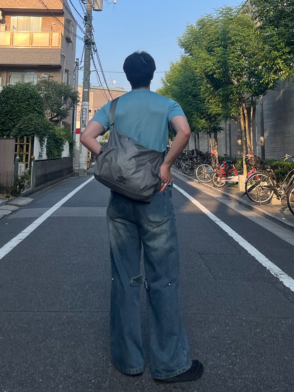 ブルー系のTシャツ/カットソー、ブルー系のデニムパンツ、ブラック系のスニーカーを着用したメンズの秋コーディネートの2枚目の写真