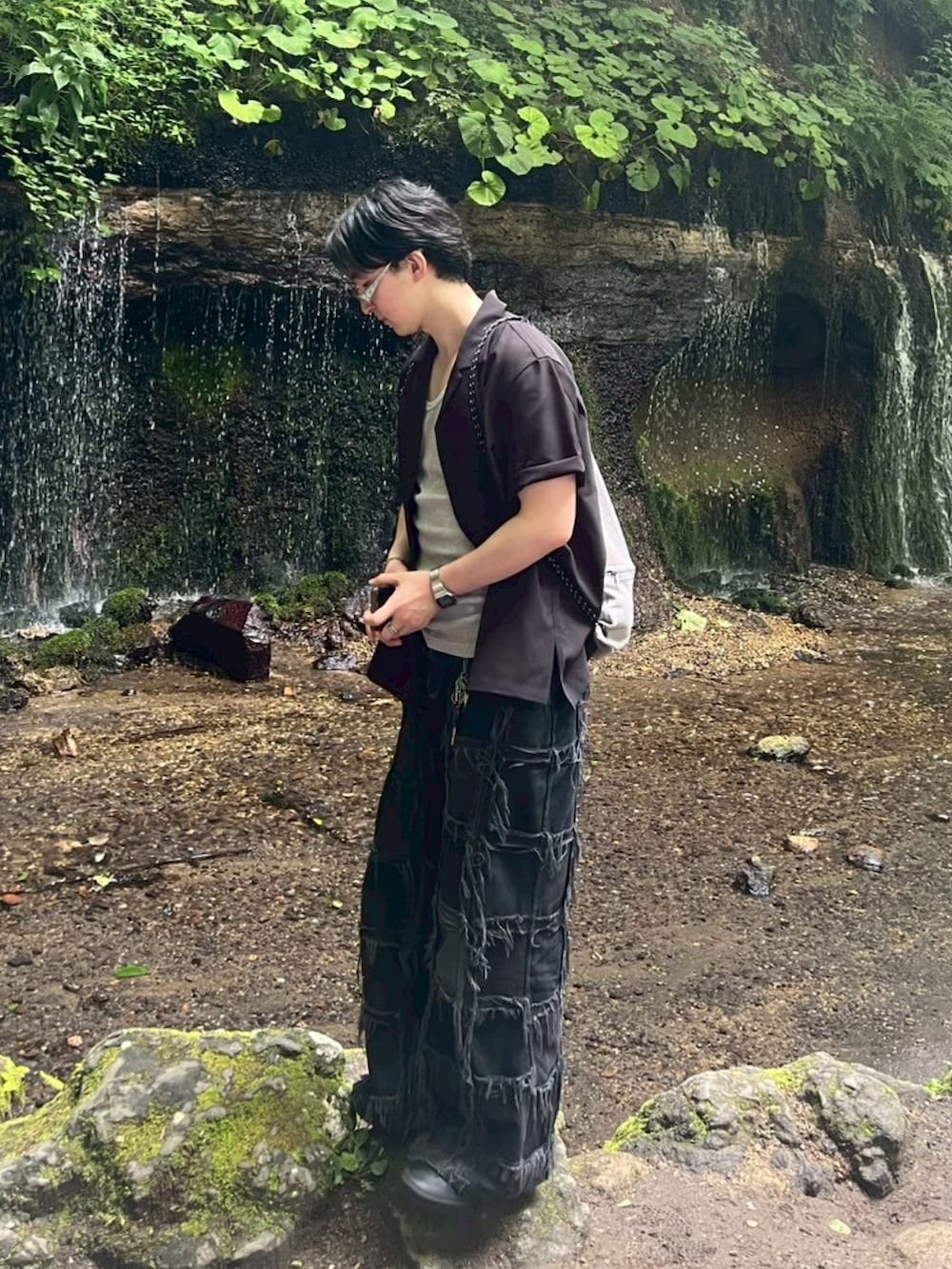 ブラック系のデニムパンツ、ブラック系のスニーカー、グレー系のバックパック/リュックを着用したメンズの秋コーディネートの2枚目の写真