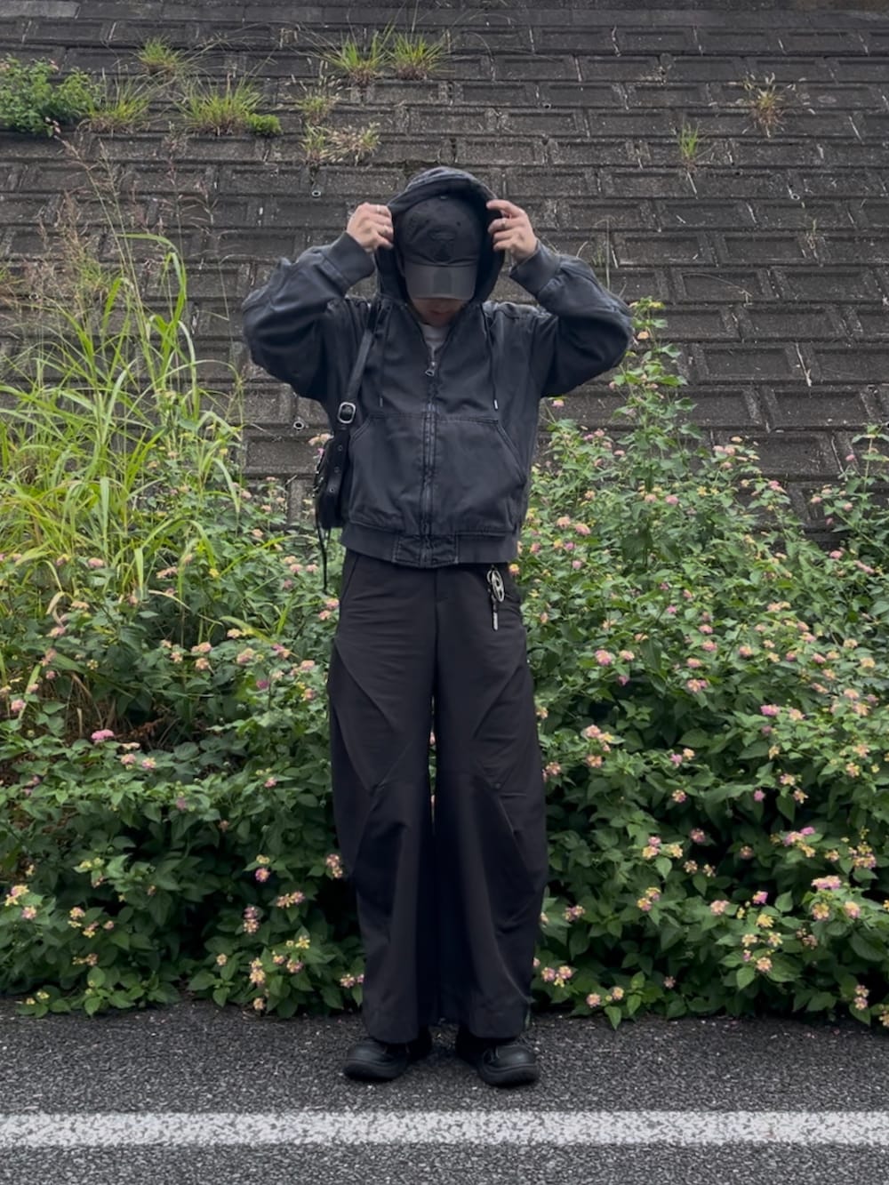 ブラック系のブルゾン、ブラック系のパンツ、ブラック系のスニーカーを着用したメンズの秋コーディネートの2枚目の写真