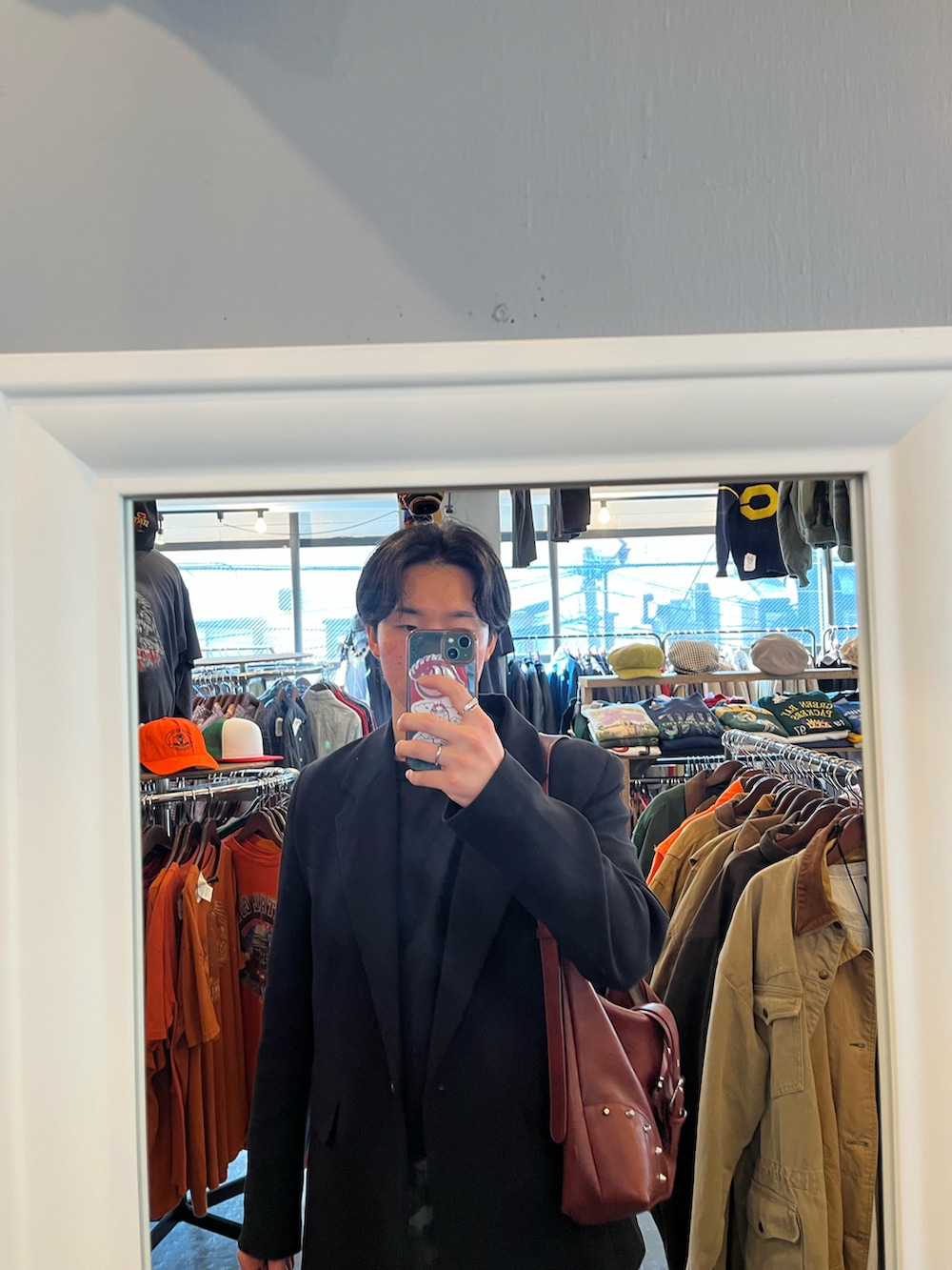 グレー系のスウェットパンツ、レッド系のショルダーバッグ、ブラック系のジャケット/アウターを着用したメンズの春コーディネートの2枚目の写真